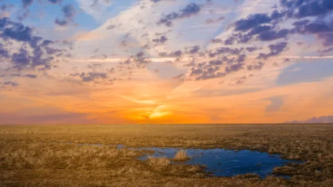 Dramatic sunset over a prairie with small lake Stock Footage 311874849