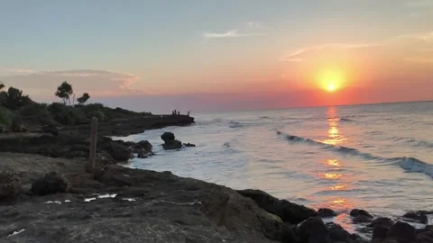 Dramatic Sunset Over Rocky Coastline and Ocean Waves Stock Footage 340416232