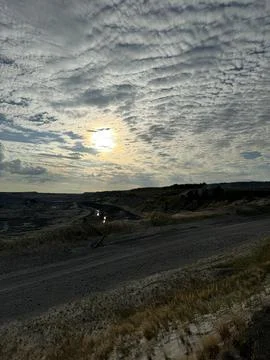 Dramatic sunset over rugged landscape with textured sky Stock Photos