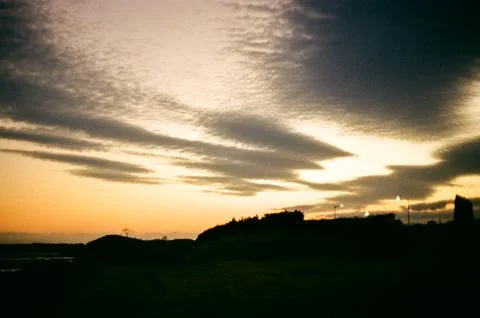 Dramatic Sunset Over a Rural Landscape With Dark Clouds 库存照片