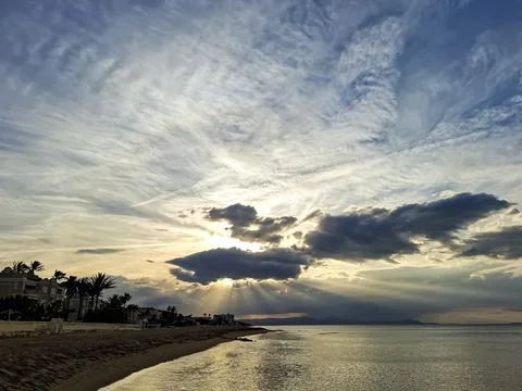 Dramatic sunset over the sea beach with sunbeams and silhouettes of palm tr.. Stock Photos