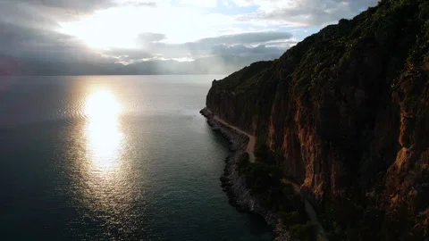 Dramatic sunset over sea cliffs and mountains in Nafplio, Greece, aerial view. Stock Footage 336182767