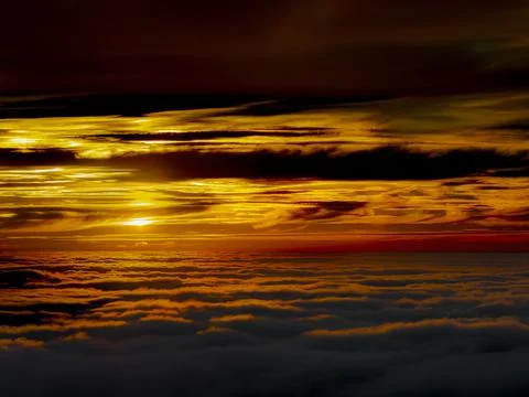 Dramatic sunset over a sea of clouds with vibrant orange and yellow hues Fotos de archivo