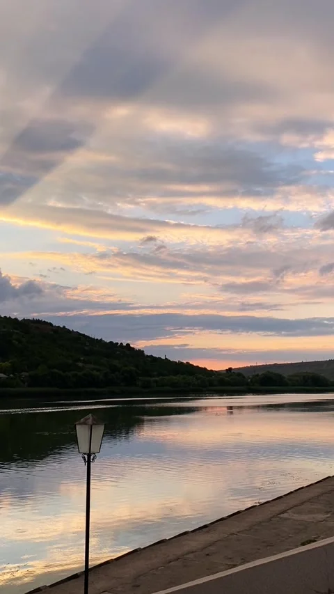 Dramatic sunset over serene river with reflected sky and mountains Stock Footage 301782052