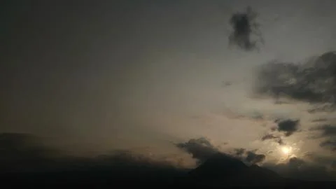 Dramatic Sunset Over Silhouetted Mountains with Sun Breaking Through Clouds Stock Photos