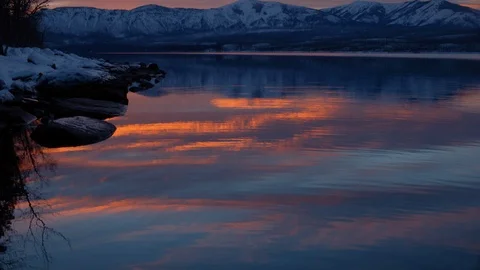 Dramatic sunset over snowy mountains and an icy water Stock Footage 113230345