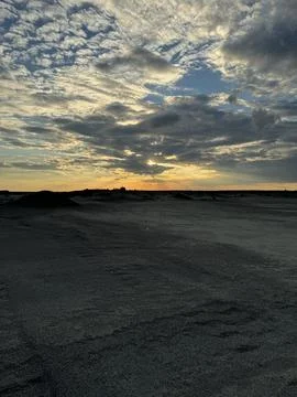 Dramatic sunset over a textured sandy landscape Stock Photos