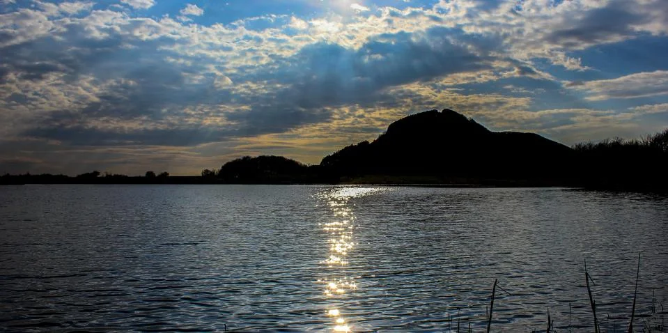 Dramatic sunset over the tranquil lake Stock Photos