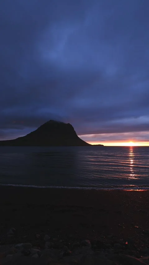 Dramatic sunset over a tranquil sea with Kirkjufell mountain silhouette Stock Footage 344058261