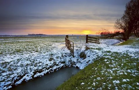 Dramatic sunset over typical Dutch farmland in winter Stock Photos