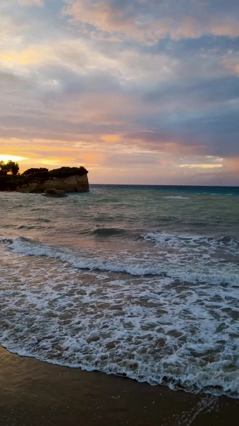 Dramatic Sunset Over Waves Crashing on Peroulades Beach in Corfu Greece Stock Footage 336180229