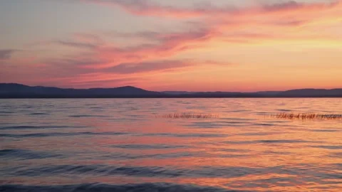 Dramatic sunset overlooking the lake. Mirror reflection of the sky on the water. Stock Footage 243338682