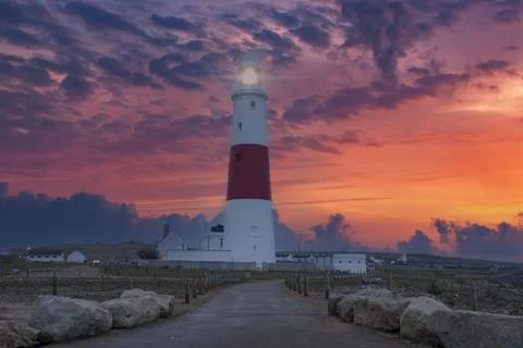 A dramatic sunset at the Portland Bill lighthouse on the south coast of England Photos