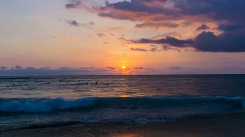 Dramatic sunset with purple clouds over surfers in ocean time lapse 스톡 동영상 78068540