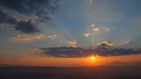 Dramatic sunset rays across layered mountains Stock Photos
