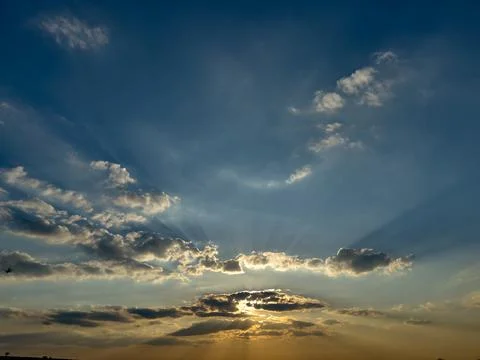 Dramatic sunset with rays and the sun behind the clouds Stock-Fotos