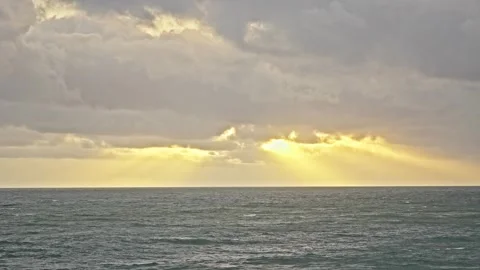 Dramatic Sunset Rays Breaking Through Clouds Over the Ocean Stock Footage 296570335