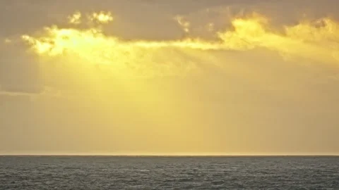 Dramatic Sunset Rays Breaking Through Clouds Over the Ocean Stock Footage 296570503