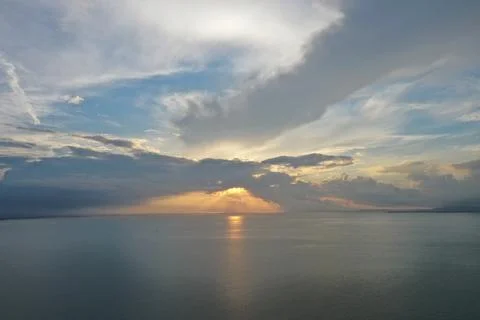 Dramatic Sunset Rays Over Calm Sea with Stormy Clouds, South China Sea Stock Photos