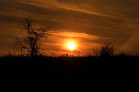 Dramatic sunset rays through a cloudy dark sky above the mountain. 写真素材