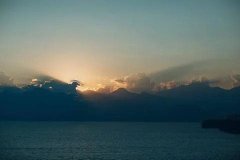 Dramatic sunset rays through cloudy dark sky over the ocean Dramatic sunse... Stock Photos