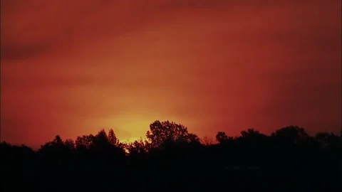 Dramatic Sunset Rising Over Tree Line in Warm Hues Video stock 327269681