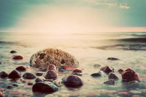 Dramatic sunset on a rocky beach. baltic sea. seascape theme, vintage Foto stock