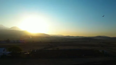 A dramatic sunset scene captured by a drone, featuring silhouettes of crows glid 動画素材 322150679