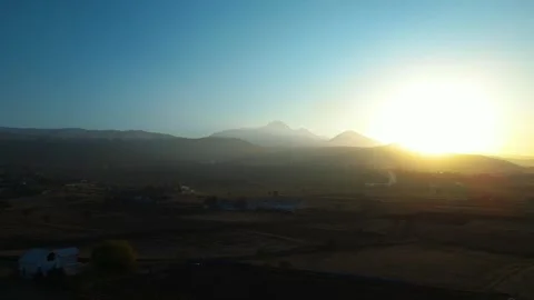 A dramatic sunset scene captured by a drone, featuring silhouettes of crows glid 動画素材 322150709