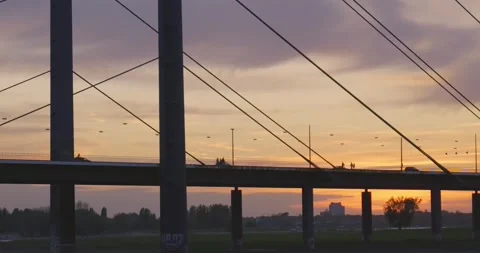 Dramatic Sunset Silhouette of Cable-Stayed Bridge with Pedestrians Walking Stock Footage 324117349
