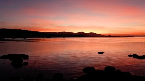Dramatic sunset with silhouette of mountain and boat over calm water sea surf Vídeos de archivo 94388255