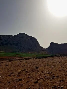 Dramatic sunset silhouettes two hills in deep shadow at Bab el-Babat near Kelti Stock Photos