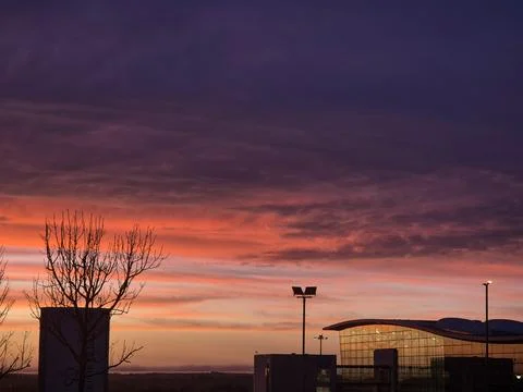 Dramatic sunset sky above modern building silhouette 스톡 사진