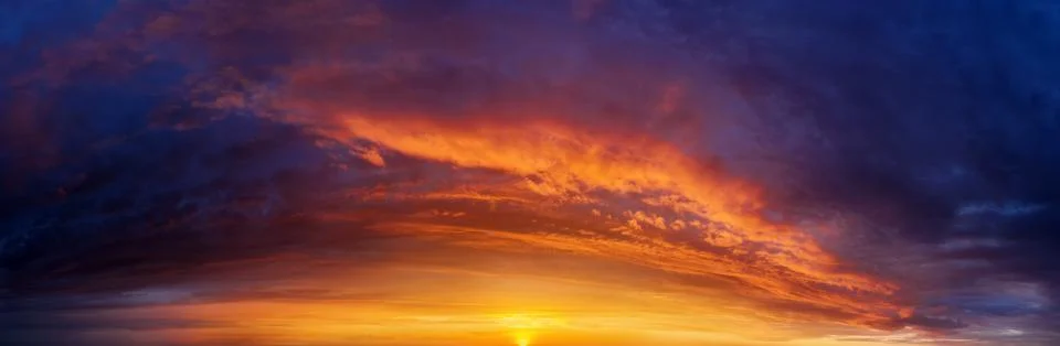 Dramatic sunset sky background with dark clouds. Stock Photos