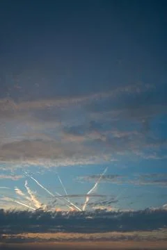 Dramatic Sunset Sky with Clouds and Airplane Contrails Stock Photos