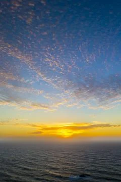 Dramatic sunset sky with clouds over the ocean Stock Photos