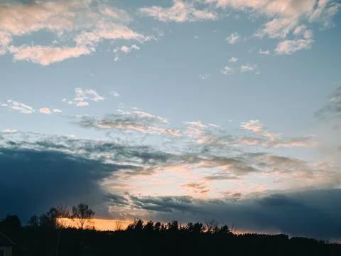Dramatic Sunset Sky with Clouds Over Forest Silhouette Stock Photos