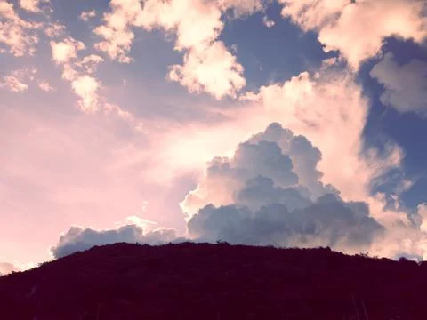Dramatic sunset sky with clouds under mountains Stock Photos