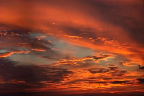 Dramatic sunset sky with colorful clouds and sun lights vivid colors Stock Photos