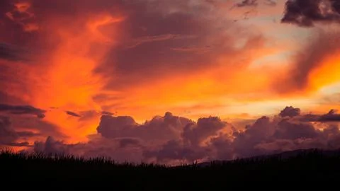 Dramatic Sunset Sky with Colorful Clouds and Grass Silhouette Stock Photos