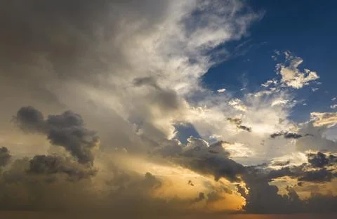 Dramatic sunset sky covered with colorful yellow clouds. Panoramic skyscape Stock Photos