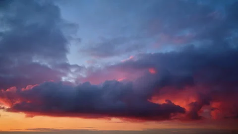 Dramatic sunset sky with dark and illuminated clouds in shades of orange, pink, Stock Footage 303723050