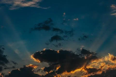 Dramatic sunset sky with dark clouds and rays of sunlight breaking through,.. Stock Photos