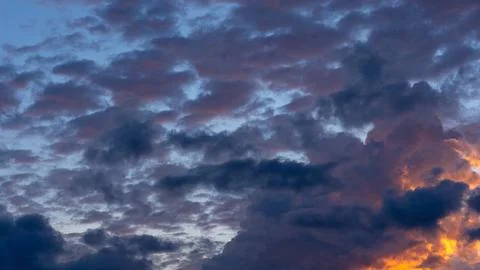 Dramatic sunset sky with dark cumulus clouds and golden light 스톡 사진
