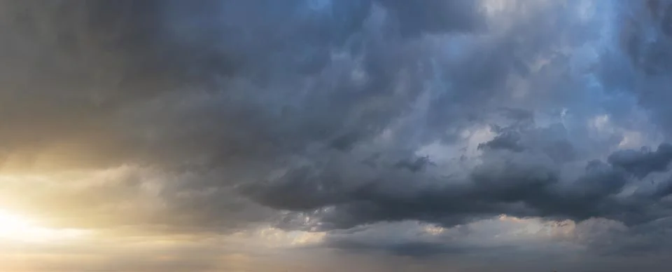 Dramatic sunset sky with dark rainy clouds. Nature background. Sky panorama. Stock Photos