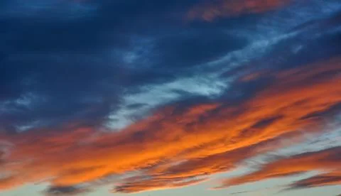 Dramatic sunset sky with deep blue and orange clouds Stock Photos