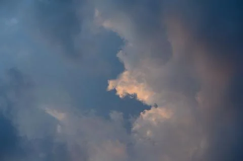Dramatic sunset sky with dense dark clouds and golden highlights breaking t.. Stock Photos