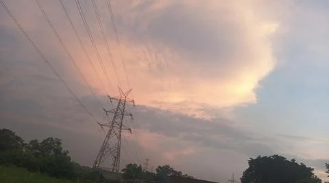 Dramatic sunset sky with dramatic clouds and electric tower Stock Photos