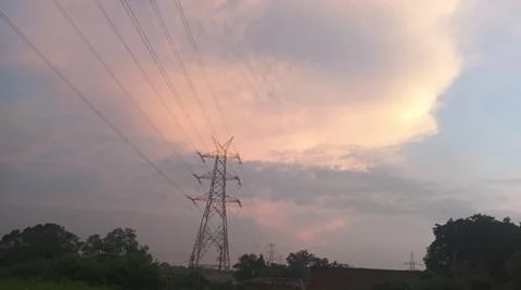 Dramatic sunset sky with dramatic clouds and electric tower Stock Photos