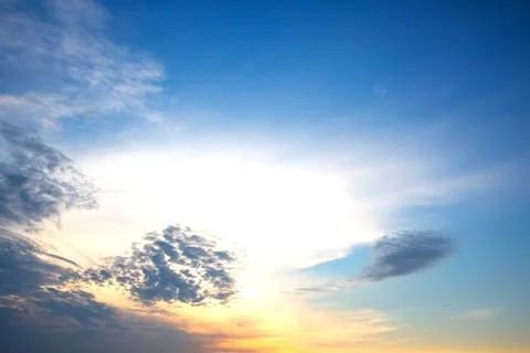 Dramatic sunset sky featuring golden, fiery clouds against a deepening blue.. Stock Photos